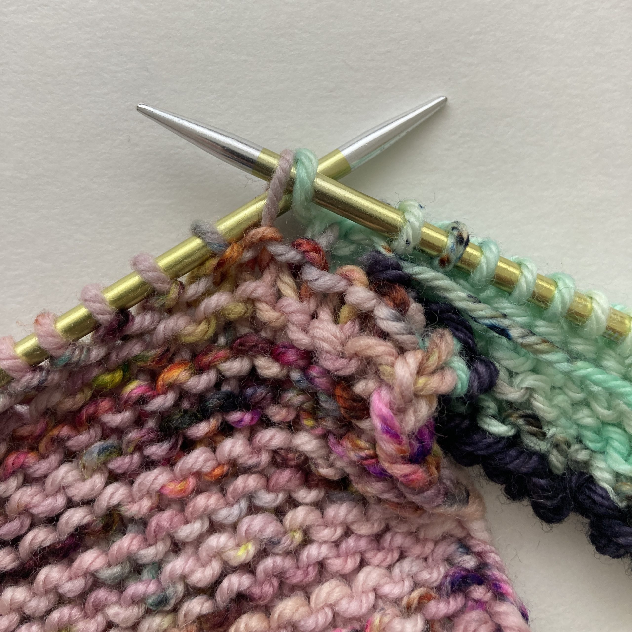 (RS) at end of row. SL1WYIF from last stitch (green) on needle, then SL1WYIF from live stitches to be joined (pink).